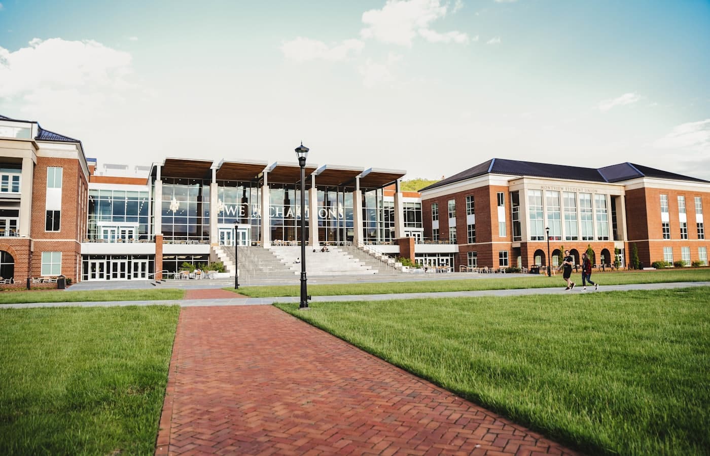 Students walking across a campus lawn