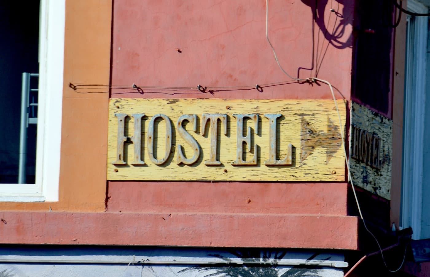 A weathered wooden hostel sign